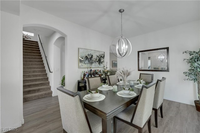 10167 Bishops Peak Ct, Las Vegas, NV 89141 - dining room with stairway, wood finished floors, a chandelier, and arched walkways