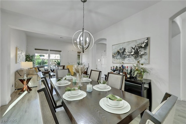 10167 Bishops Peak Ct, Las Vegas, NV 89141 - dining room featuring arched walkways, wood finished floors, and a chandelier