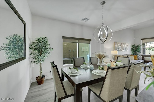 10167 Bishops Peak Ct, Las Vegas, NV 89141 - dining space with a chandelier and light wood-style flooring