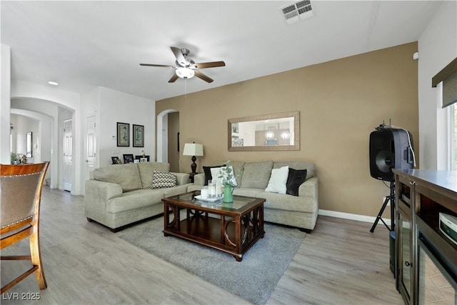10167 Bishops Peak Ct, Las Vegas, NV 89141 - living area featuring arched walkways, a ceiling fan, light wood-type flooring, and beverage cooler