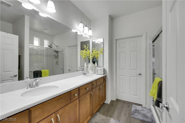 10167 Bishops Peak Ct, Las Vegas, NV 89141 - full bathroom featuring a stall shower, double vanity, and wood finished floors