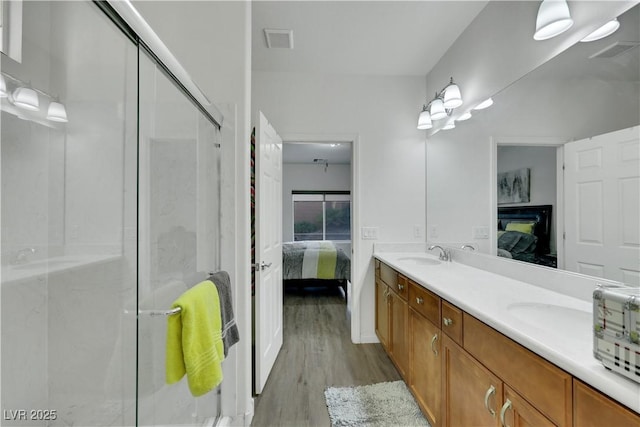 10167 Bishops Peak Ct, Las Vegas, NV 89141 - bathroom with connected bathroom, wood finished floors, double vanity, and a shower stall