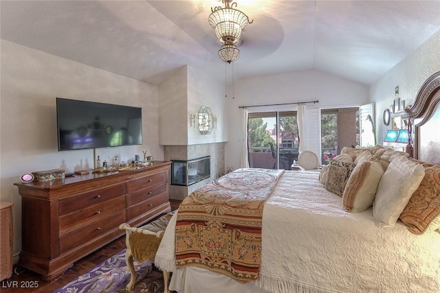 5046 Crooked Stick Way, Las Vegas, NV 89113 - bedroom featuring lofted ceiling, access to exterior, wood finished floors, and a multi sided fireplace