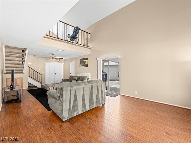 3740 Broadriver Dr, Las Vegas, NV 89108 - living room with stairs, hardwood / wood-style flooring, ceiling fan, and a towering ceiling