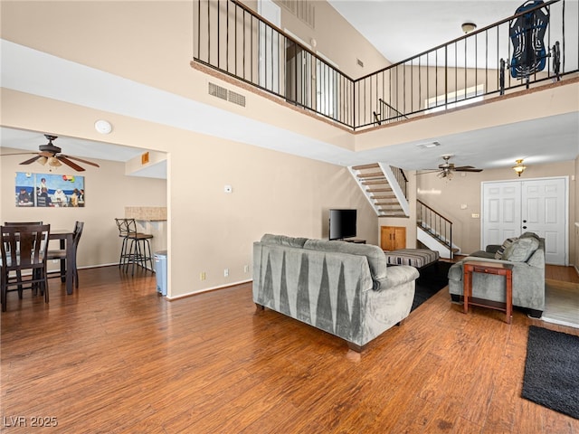 3740 Broadriver Dr, Las Vegas, NV 89108 - living room featuring a ceiling fan, stairway, a high ceiling, and wood finished floors