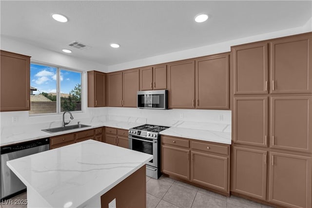 11010 Santorini Dr, Las Vegas, NV 89141 - kitchen featuring appliances with stainless steel finishes, light stone countertops, light tile patterned flooring, a kitchen island, and recessed lighting