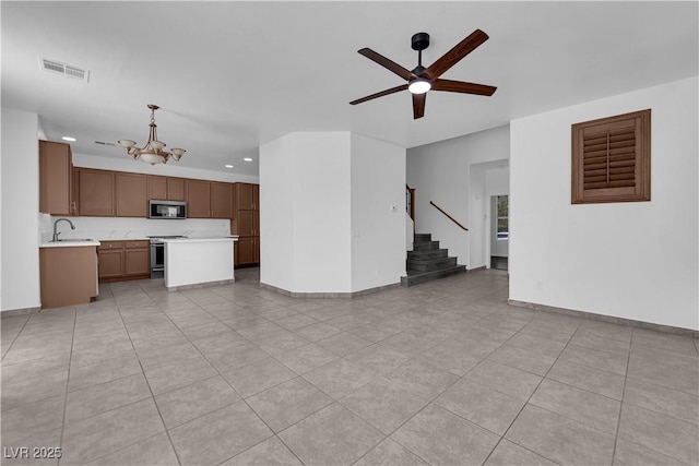 11010 Santorini Dr, Las Vegas, NV 89141 - unfurnished living room with a chandelier, stairway, recessed lighting, a ceiling fan, and light tile patterned floors