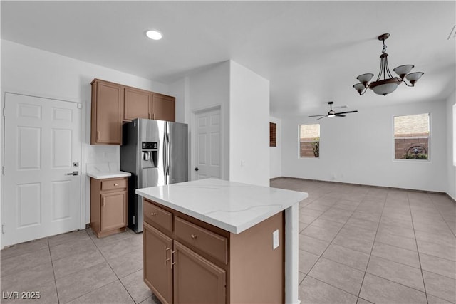 11010 Santorini Dr, Las Vegas, NV 89141 - kitchen featuring a chandelier, light tile patterned flooring, stainless steel fridge, a ceiling fan, and decorative light fixtures