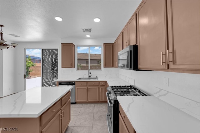 11010 Santorini Dr, Las Vegas, NV 89141 - kitchen with stainless steel appliances, light tile patterned flooring, a center island, recessed lighting, and light stone countertops