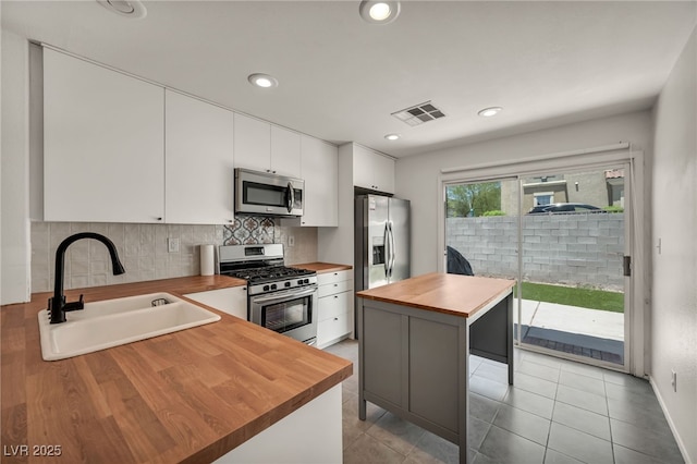 4020 Pistachio Nut Ave, Las Vegas, NV 89115 - kitchen featuring butcher block countertops, stainless steel appliances, tasteful backsplash, white cabinetry, and recessed lighting