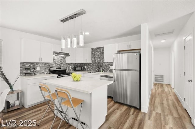 3208 Alcoa Ave, Las Vegas, NV 89102 - kitchen featuring stainless steel appliances, a center island, backsplash, white cabinets, and light countertops