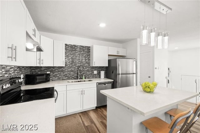 3208 Alcoa Ave, Las Vegas, NV 89102 - kitchen with stainless steel appliances, a kitchen breakfast bar, decorative backsplash, light countertops, and white cabinets