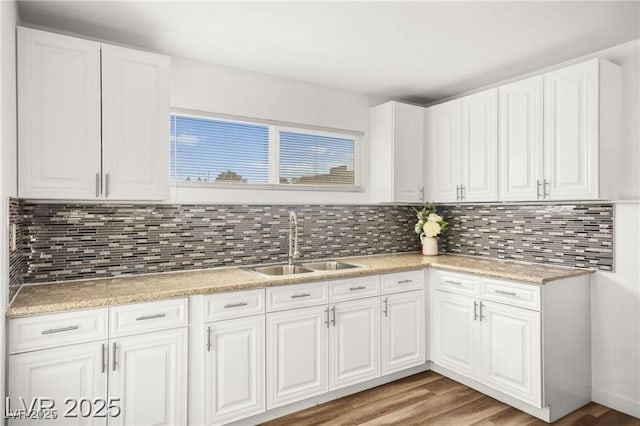 3208 Alcoa Ave, Las Vegas, NV 89102 - kitchen with light countertops, white cabinets, light wood-style floors, and tasteful backsplash