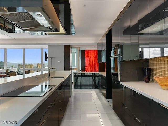 4471 Dean Martin Dr Unit 4308, Las Vegas, NV 89103 - kitchen with modern cabinets, dark cabinets, exhaust hood, and light tile patterned flooring