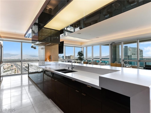 4471 Dean Martin Dr Unit 4308, Las Vegas, NV 89103 - kitchen with light tile patterned floors, dark cabinetry, modern cabinets, light countertops, and black electric stovetop