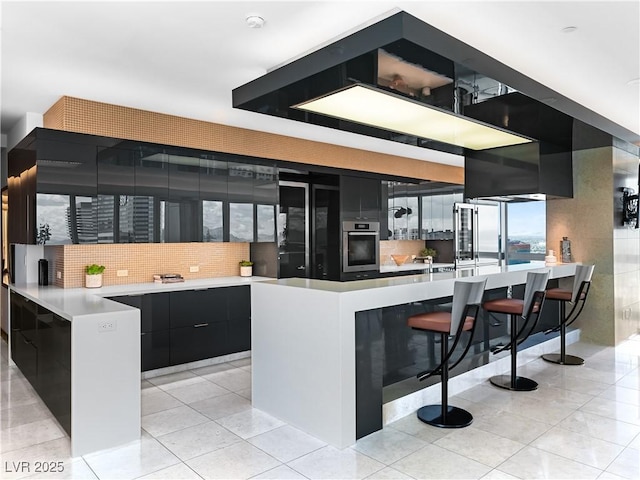 4471 Dean Martin Dr Unit 4308, Las Vegas, NV 89103 - kitchen with appliances with stainless steel finishes, dark cabinets, modern cabinets, light countertops, and light tile patterned flooring