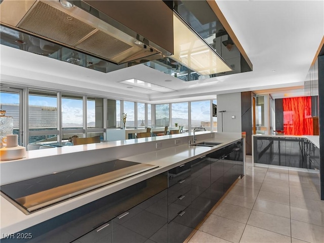 4471 Dean Martin Dr Unit 4308, Las Vegas, NV 89103 - kitchen with range hood, light tile patterned floors, modern cabinets, and black electric cooktop