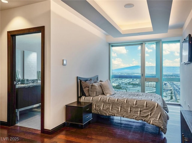 4471 Dean Martin Dr Unit 4308, Las Vegas, NV 89103 - bedroom featuring wood finished floors, a tray ceiling, and ensuite bath