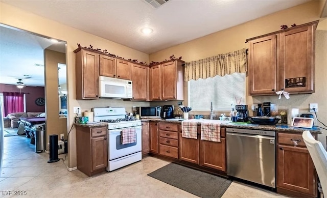 3109 Frigate Way N, Las Vegas, NV 89084 - kitchen with stainless steel appliances, a ceiling fan, dark countertops, and brown cabinets
