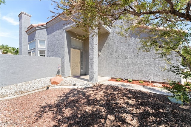 1337 Maplegrove Cir, Las Vegas, NV 89108 - view of exterior entry featuring stucco siding and a chimney