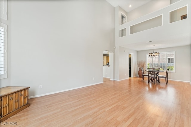 1337 Maplegrove Cir, Las Vegas, NV 89108 - living area featuring a chandelier, arched walkways, light wood-style flooring, a towering ceiling, and recessed lighting
