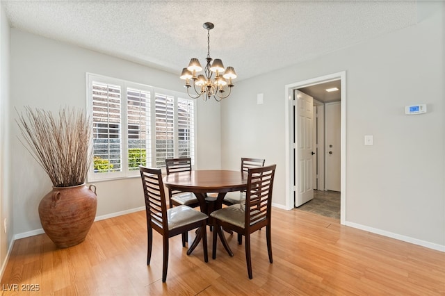 1337 Maplegrove Cir, Las Vegas, NV 89108 - dining area featuring light wood-style floors, a chandelier, and a textured ceiling