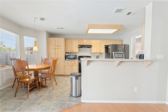1337 Maplegrove Cir, Las Vegas, NV 89108 - kitchen with appliances with stainless steel finishes, light brown cabinetry, under cabinet range hood, and a breakfast bar