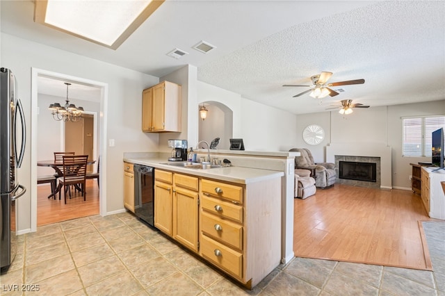 1337 Maplegrove Cir, Las Vegas, NV 89108 - kitchen featuring black dishwasher, freestanding refrigerator, ceiling fan, a tile fireplace, and arched walkways