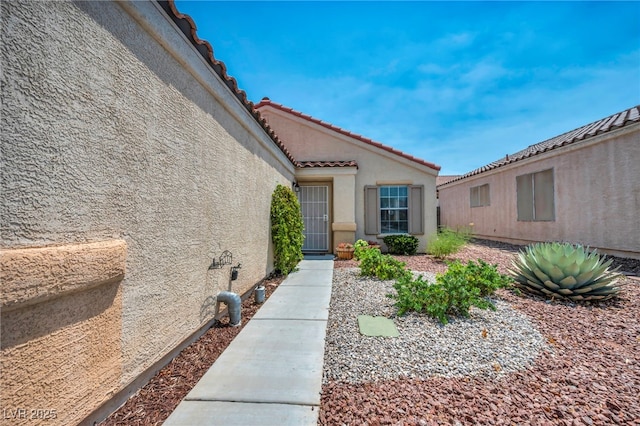 8557 Hidden Pines Ave, Las Vegas, NV 89143 - view of exterior entry featuring stucco siding and a tile roof