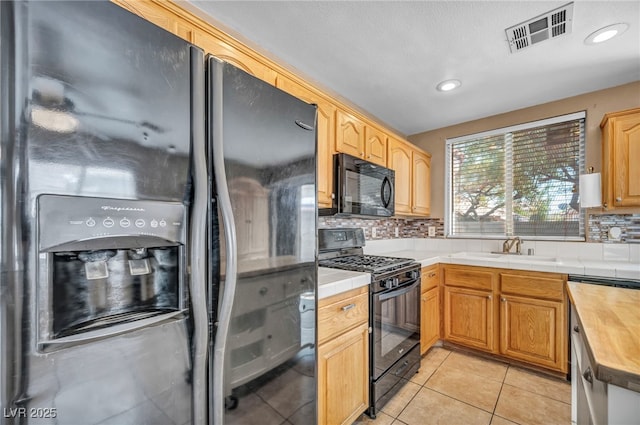 8557 Hidden Pines Ave, Las Vegas, NV 89143 - kitchen featuring black appliances, backsplash, light tile patterned floors, tile counters, and recessed lighting