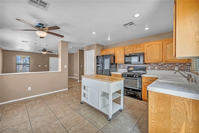 8557 Hidden Pines Ave, Las Vegas, NV 89143 - kitchen featuring black appliances, a ceiling fan, open shelves, tasteful backsplash, and light tile patterned flooring