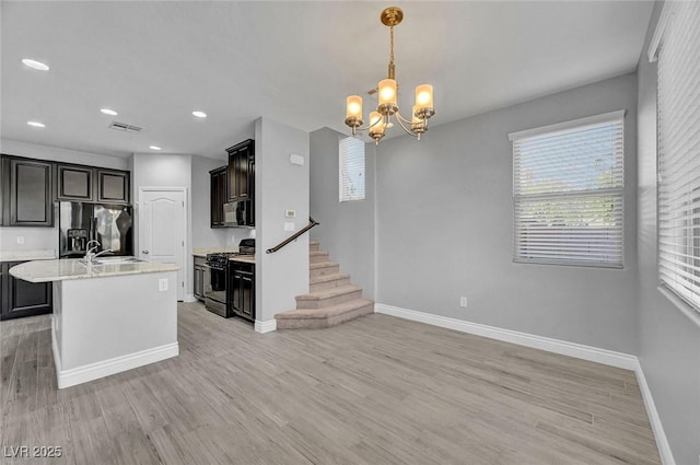 6373 Beavertail Pond Ave, Las Vegas, NV 89122 - kitchen with black appliances, a chandelier, light wood-style flooring, an island with sink, and recessed lighting
