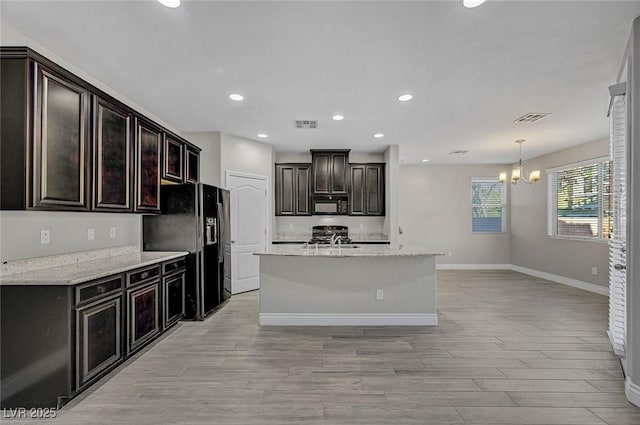 6373 Beavertail Pond Ave, Las Vegas, NV 89122 - kitchen with black appliances, a chandelier, recessed lighting, light wood-style floors, and an island with sink