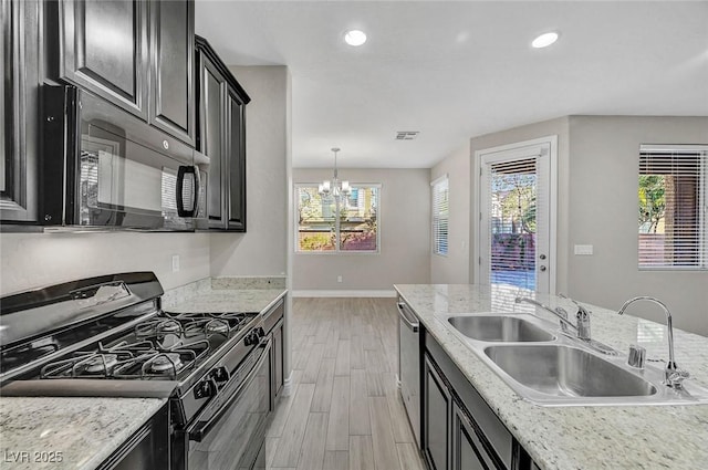 6373 Beavertail Pond Ave, Las Vegas, NV 89122 - kitchen with black appliances, wood finish floors, a chandelier, recessed lighting, and dark cabinets