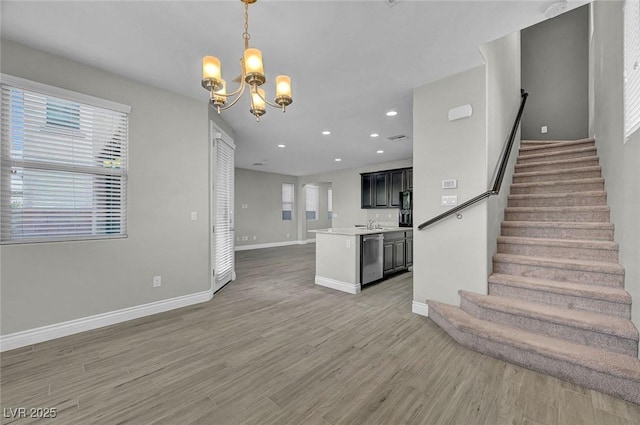 6373 Beavertail Pond Ave, Las Vegas, NV 89122 - unfurnished living room featuring light wood finished floors, stairs, a chandelier, healthy amount of natural light, and recessed lighting