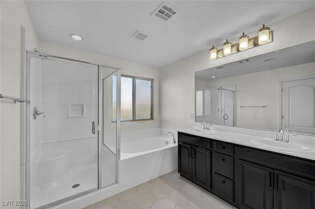 6373 Beavertail Pond Ave, Las Vegas, NV 89122 - bathroom with double vanity, a shower stall, a garden tub, tile patterned floors, and recessed lighting