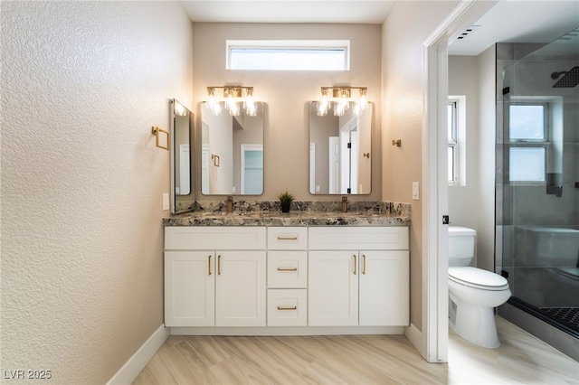 8904 Marble Dr, Las Vegas, NV 89134 - bathroom featuring double vanity, a shower stall, a textured wall, and wood finished floors