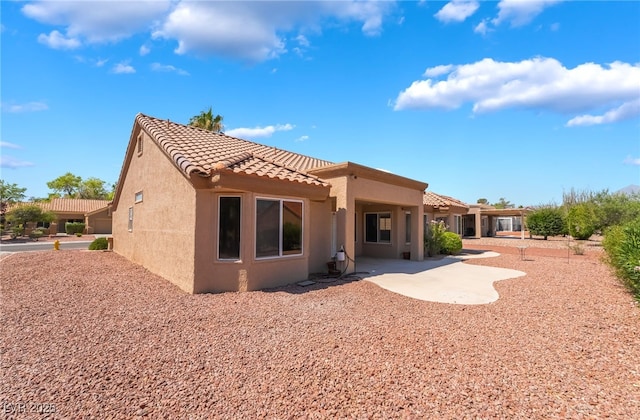 8904 Marble Dr, Las Vegas, NV 89134 - back of house featuring stucco siding, a tiled roof, and a patio