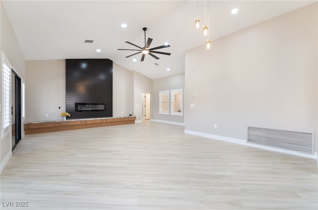 8904 Marble Dr, Las Vegas, NV 89134 - unfurnished living room with light wood-style flooring, a fireplace, a ceiling fan, high vaulted ceiling, and recessed lighting