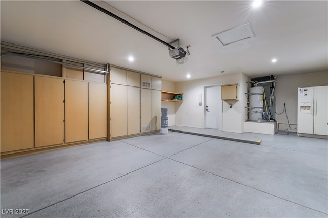 8904 Marble Dr, Las Vegas, NV 89134 - garage featuring white fridge with ice dispenser, a garage door opener, recessed lighting, and secured water heater