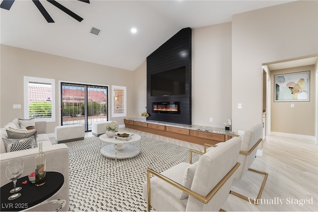 8904 Marble Dr, Las Vegas, NV 89134 - living area with high vaulted ceiling, a large fireplace, light wood-style flooring, and ceiling fan