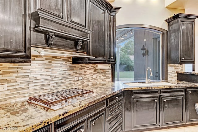 7751 Radcliff St, Las Vegas, NV 89123 - kitchen featuring stainless steel gas stovetop, tasteful backsplash, light stone counters, and arched walkways