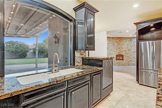 7751 Radcliff St, Las Vegas, NV 89123 - kitchen featuring appliances with stainless steel finishes, stone counters, light tile patterned flooring, and dark brown cabinetry