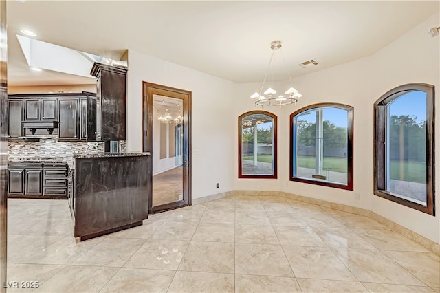 7751 Radcliff St, Las Vegas, NV 89123 - kitchen featuring a chandelier, decorative backsplash, healthy amount of natural light, and stone counters