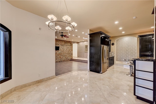 7751 Radcliff St, Las Vegas, NV 89123 - kitchen with freestanding refrigerator, arched walkways, ceiling fan, a chandelier, and recessed lighting