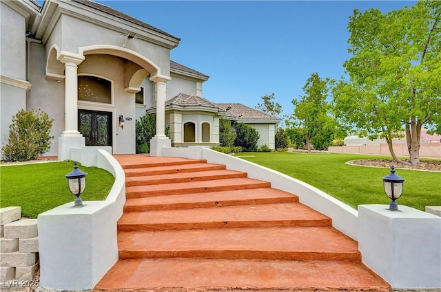 7751 Radcliff St, Las Vegas, NV 89123 - view of exterior entry featuring french doors, a lawn, and stucco siding