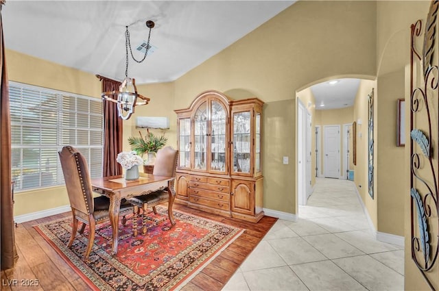 216 Chestnut Ridge Cir, Henderson, NV 89012 - dining space with arched walkways, a chandelier, light wood-type flooring, and vaulted ceiling