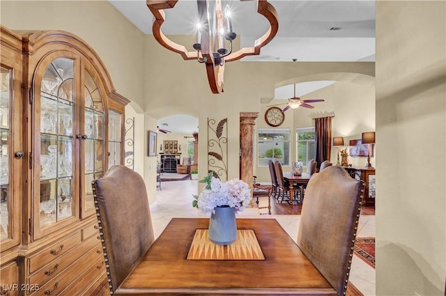 216 Chestnut Ridge Cir, Henderson, NV 89012 - dining room with arched walkways, a chandelier, ceiling fan, a high ceiling, and tile patterned floors