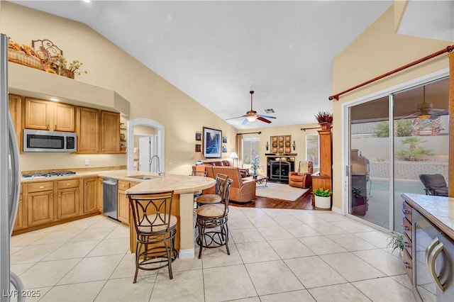 216 Chestnut Ridge Cir, Henderson, NV 89012 - kitchen featuring stainless steel appliances, a ceiling fan, a peninsula, open floor plan, and a kitchen breakfast bar