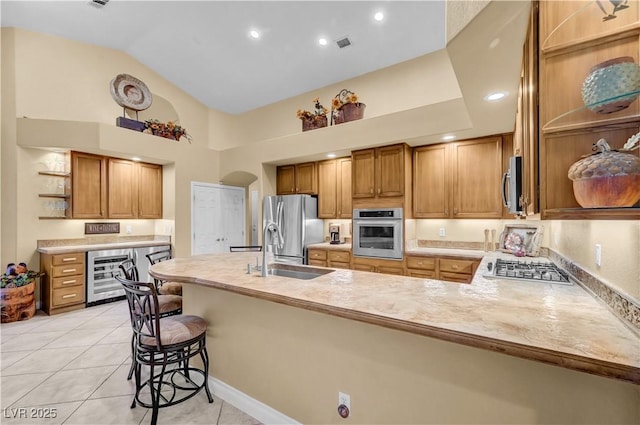 216 Chestnut Ridge Cir, Henderson, NV 89012 - kitchen with stainless steel appliances, wine cooler, open shelves, a peninsula, and a breakfast bar